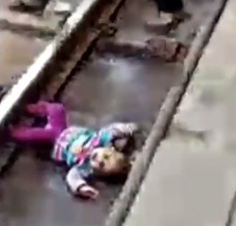 Heart-stopping moment 1-year-old baby fell onto train tracks and a train passed over her but she miraculously survived without a scratch (video)