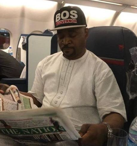 Photos of MC Oluomo on a plane heading to the US after surviving multiple stab wounds at APC Lagos rally
