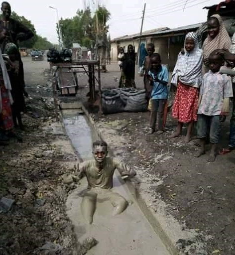 Another man dips himself inside dirty gutter to celebrate President Muhammadu Buhari