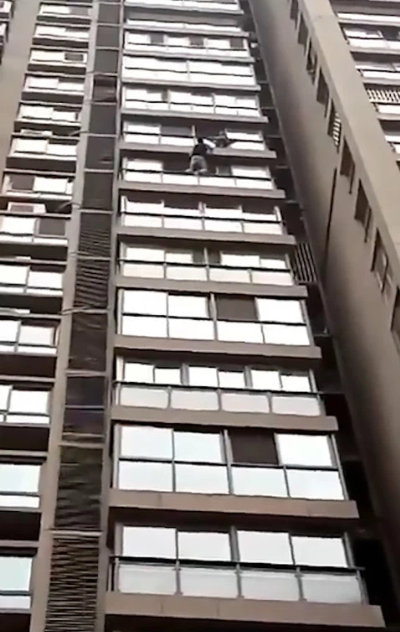 Heart-stopping moment Boy, 5, climbs out of window and clings to ledge of his 13th-floor home after parents left him alone at home