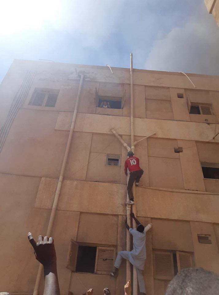 Photo: Two African migrants hailed as heroes for climbing up a building in Libya to save four children trapped inside burning third-floor flat
