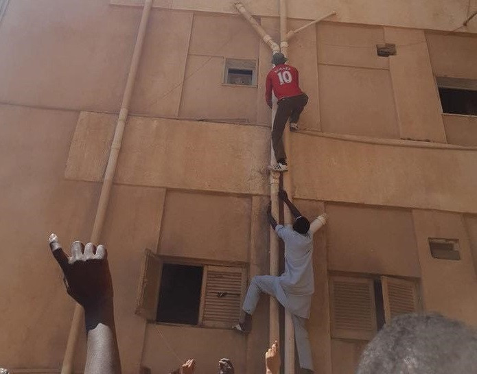 Photo: Two African migrants hailed as heroes for climbing up a building in Libya to save four children trapped inside burning third-floor flat