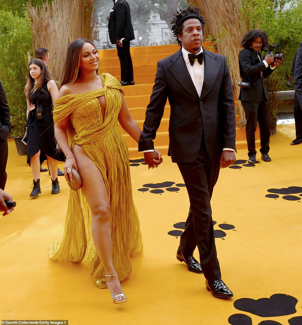 Beyonc? commands attention in a gold asymmetric gown as she joins husband Jay-Z at London