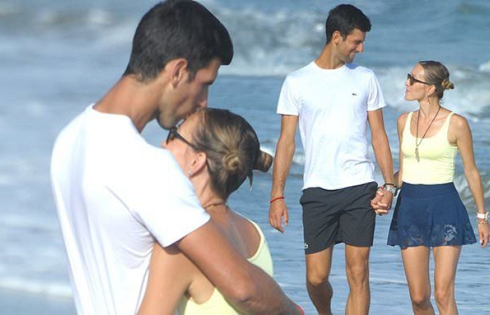 Tennis star Novak Djokovic plants a sweet kiss on wife Jelena during romantic stroll on the beach in Marbella (Photos)
