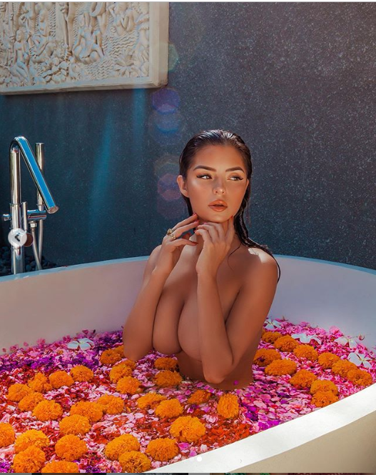 Demi Rose poses completely topless while soaking in a bath of flower petals (Photos)
