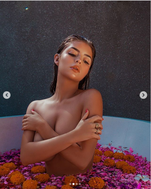 Demi Rose poses completely topless while soaking in a bath of flower petals (Photos)