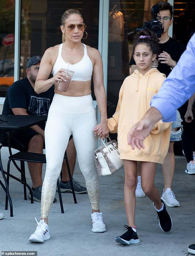 Jennifer Lopez showcases her backside in skintight white leggings and a sports bra (Photos)