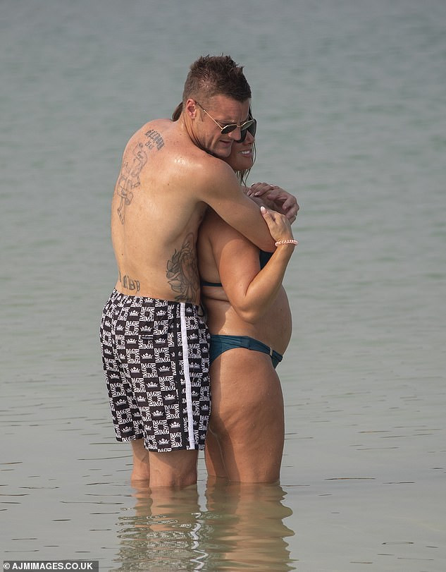 Rebekah Vardy flaunts her blossoming bump as she kisses her husband Jamie Vardy in the sea in Dubai (Photos)
