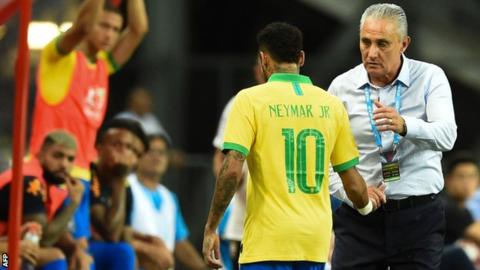 Brazil's forward Neymar (L) shakes hands with team coach Tite as he leaves the field during an international friendly football match between Brazil and Nigeria