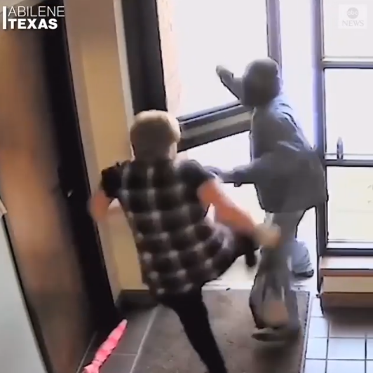 Elderly woman hailed after she was filmed bravely fighting off an armed bank robber (video)