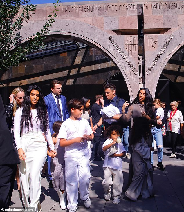 Kim Kardashian wears traditional headscarf and figure-hugging dress as she gets baptized with her children in Armenia (Photos)