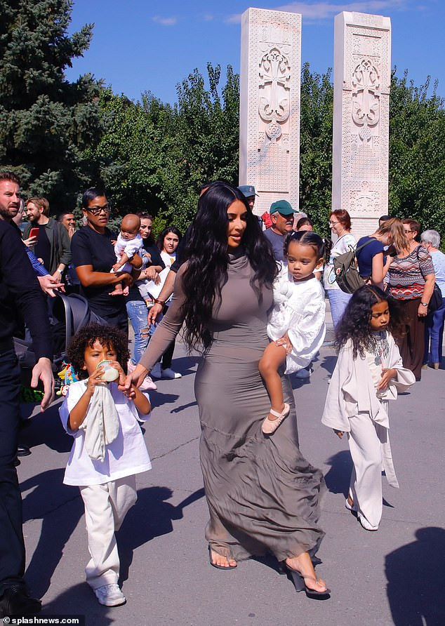 Kim Kardashian wears traditional headscarf and figure-hugging dress as she gets baptized with her children in Armenia (Photos)