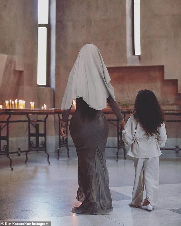 Kim Kardashian wears traditional headscarf and figure-hugging dress as she gets baptized with her children in Armenia (Photos)