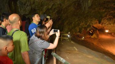 People take photographs at the entrance of the Tham Luang cave in Mae Sai district, Chiang Rai province, Thailand, on 01 November 2019.