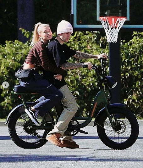 Hailey Bieber clings to Justin Bieber as they ride on his bike (photos)