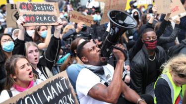 A demonstrator shouts through a megaphone outside London's US embassy