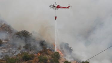 A helicopter drops water to help extinguish the Bobcat fire in Arcadia, California (13 September 2020)