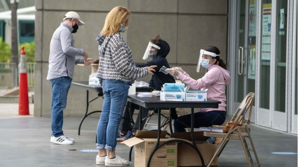 Polling center clerks assist voters outside the Staples Center as California in-person early voting for the U.S. Presidential election begins, in Los Angeles, California, USA, 24 October 2020.