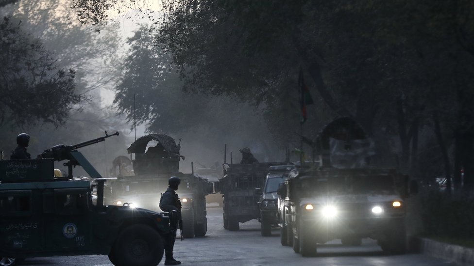 Afghan security officials stand guard at the university