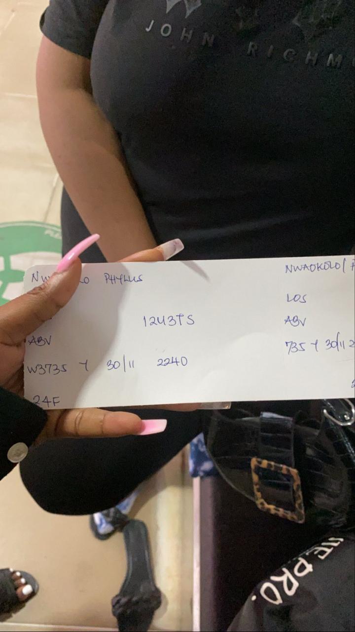 Nigerian lady shows off the boarding pass she got at an airport