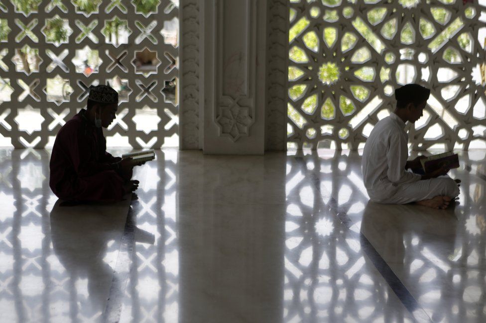 Two teenagers read the Koran