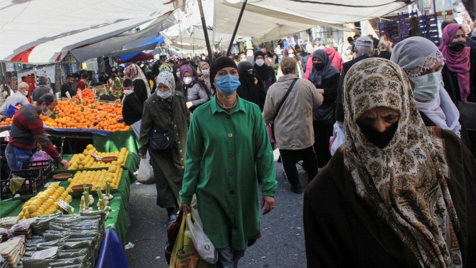 People wearing protective face masks shop at a fresh market in Istanbul, Turkey