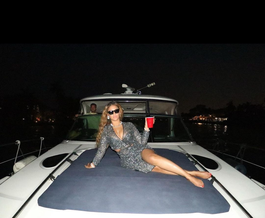 Beyonce flaunts curves in sheer gown with racy cut-outs and a plunging neckline as she lounges on a boat with close friends in Miami