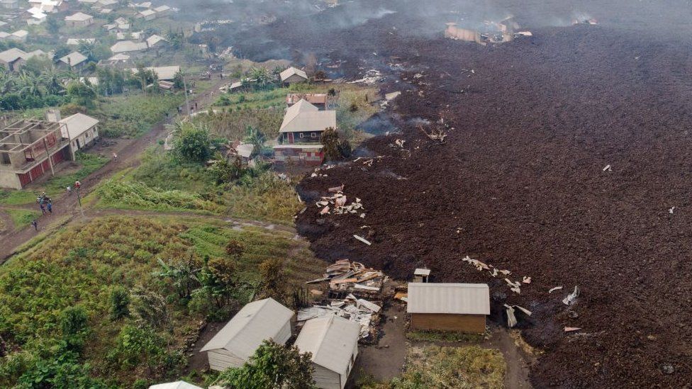 This aerial view shows debris engulfing buildings in Bushara village, Nyiragongo area, near Goma, on May 23, 2021