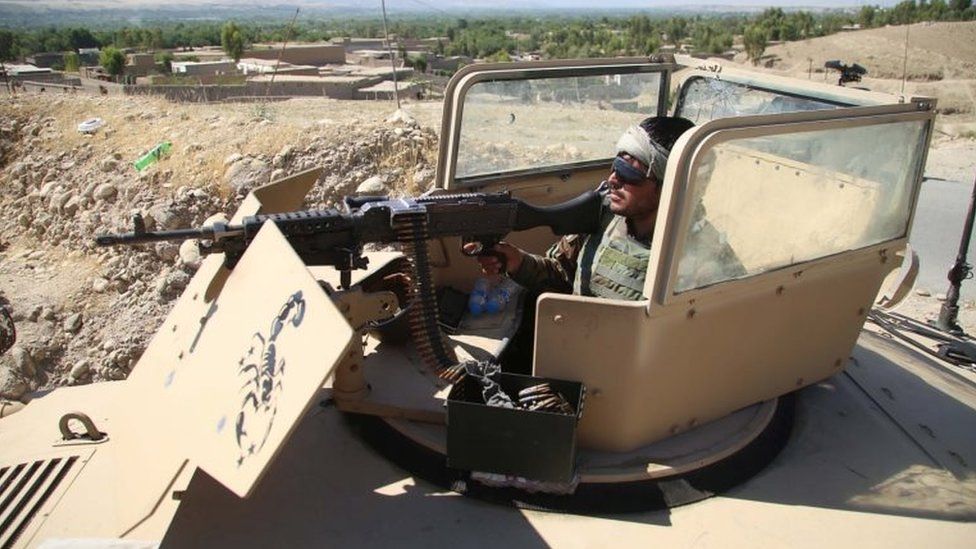 An Afghan security official stands guard at a checkpoint in Laghman province, 25 May 2021