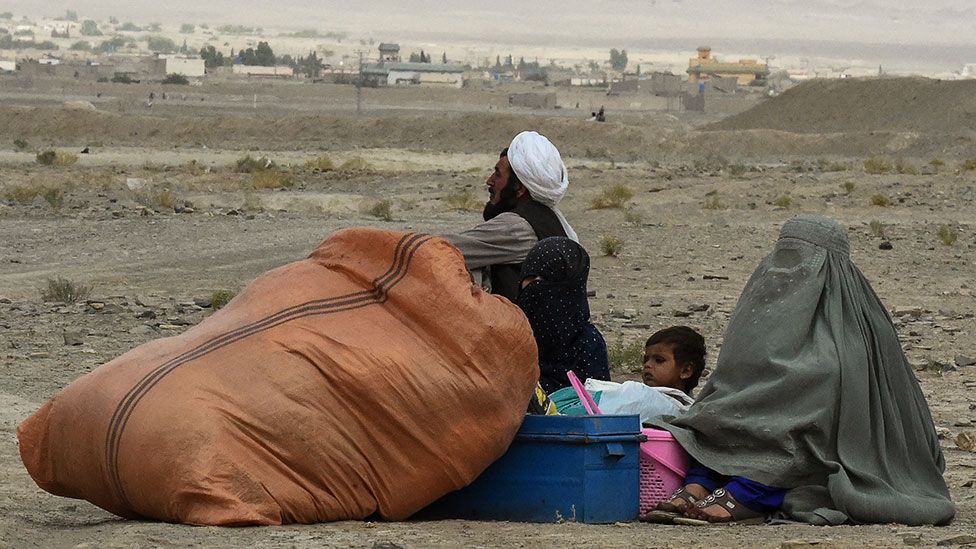 People forced to leave their homes wait for a border crossing to open