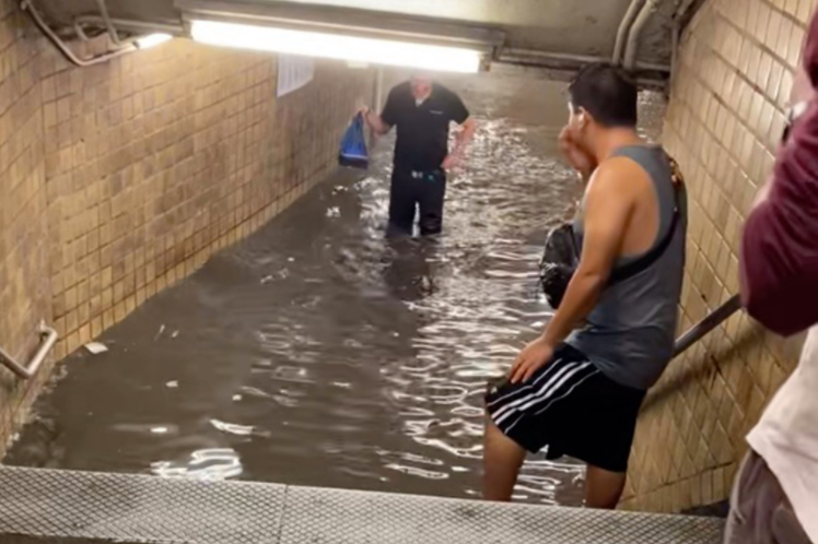 Commuters wade through dirty water as subway stations in New York flood following heavy rain (video)