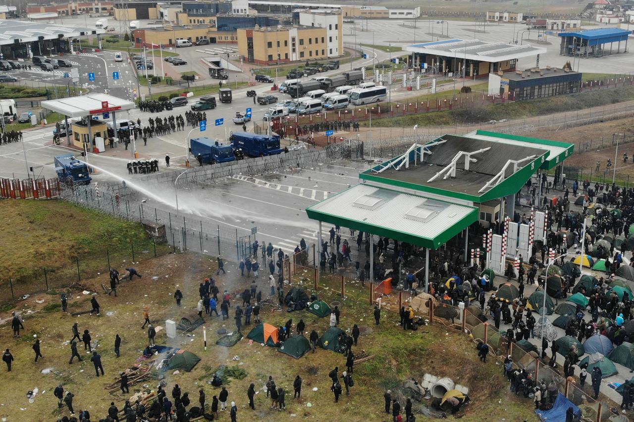 Watch Polish military use water cannons and tear gas on migrants as tensions rise at EU