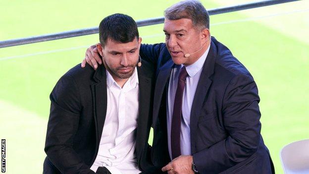 Aguero is consoled by Barcelona president Joan Laporta during the news conference