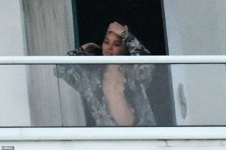 Kanye West spotted with mystery girl on hotel balcony before almost naked woman steps out of same hotel balcony (photos)