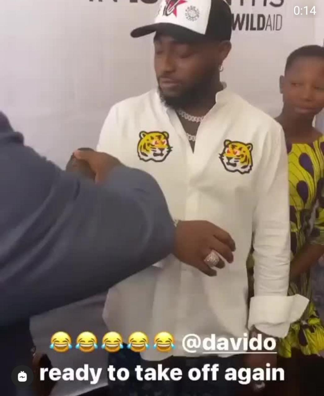 Davido unable to hide his discomfort as a pangolin is placed on his arm (video)