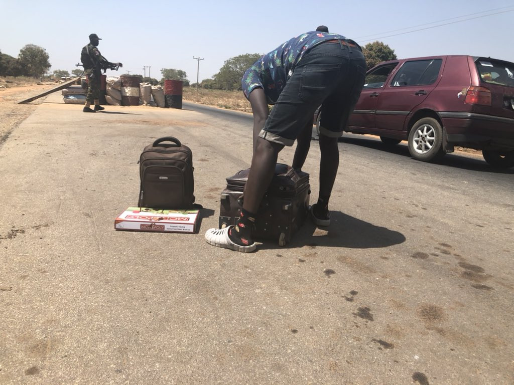 Man expresses his sadness after a military officer forcefully cuts his hair at a checkpoint in Kaduna