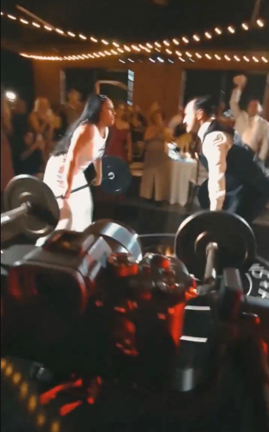 Bride and groom lift weights at their wedding reception (video)
