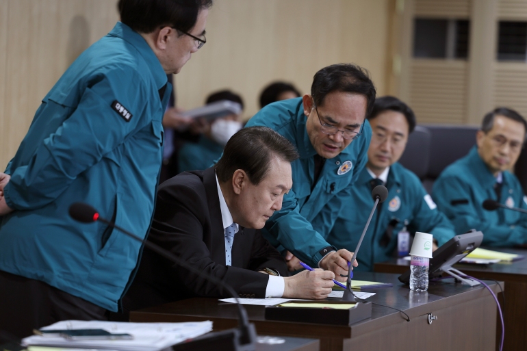 South Korean President Yoon Suk Yeol, second left, discusses issues with other officials during the National Security Council (NSC) meeting at the presidential office
