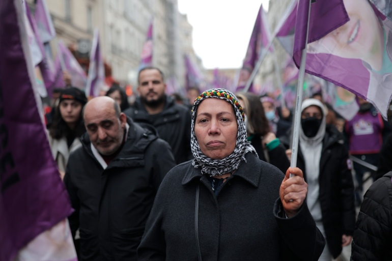 Kurdish activists hold flags during a march