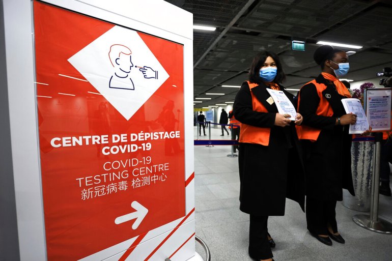 Airport staff wait from passengers coming from China in front of a COVID-19 testing area set at the Roissy Charles de Gaulle airport, north of Paris, Sunday, Jan. 1, 2023. France says it will require negative COVID-19 tests of all passengers arriving from China and is urging French citizens to avoid nonessential travel to China. (AP Photo/Aurelien Morissard)