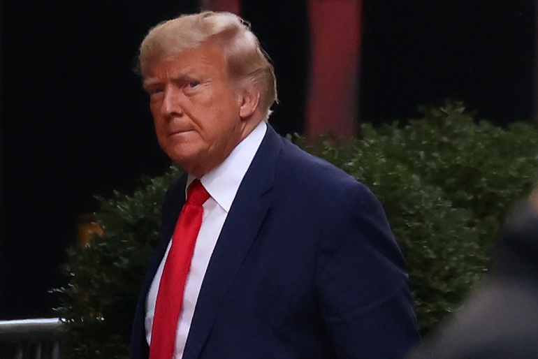 A close-up of Trump in a blue suit and red tie