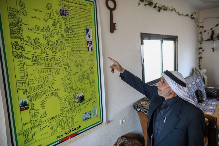 An elderly man points to a map