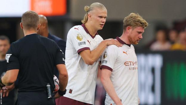 Kevin de Bruyne is consoled by team-mate Erling Haaland