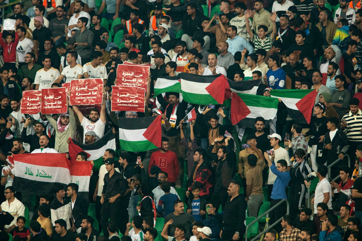 Iraq supporters wave the Palestinian flag during the 2026 FIFA World Cup AFC qualifiers football match between Iraq and Indonesia at the Basra International Stadium.