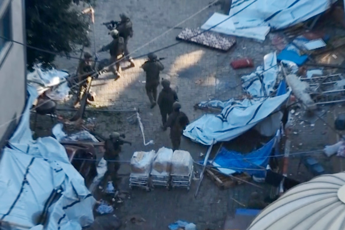 In this image taken from a video released by the Israeli Defense Forces on Tuesday, Nov. 15, 2023, Israeli soldiers walk in the area of Al-Shifa hospital in Gaza City.